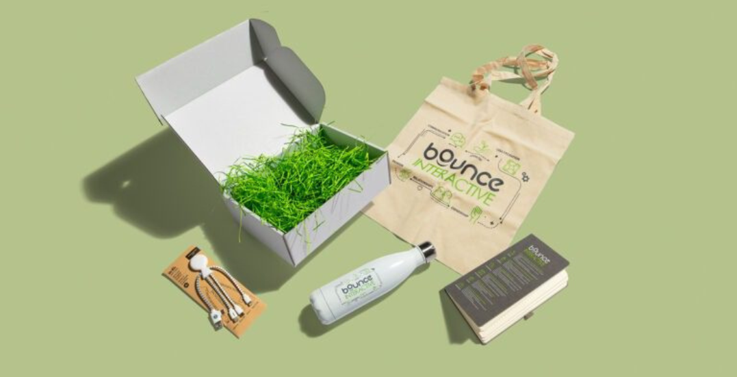 Image: Company swag containing water bottle, USBs, tote bags and branded notepad