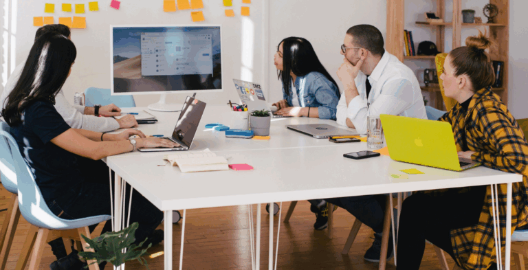 Image: People working and brainstorming around a desk