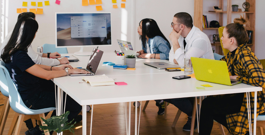Image: People working and brainstorming around a desk